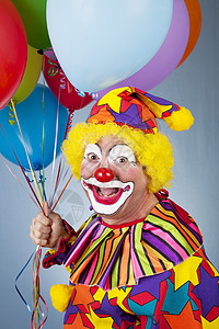 快乐小丑的肖像拿着一束气球图片