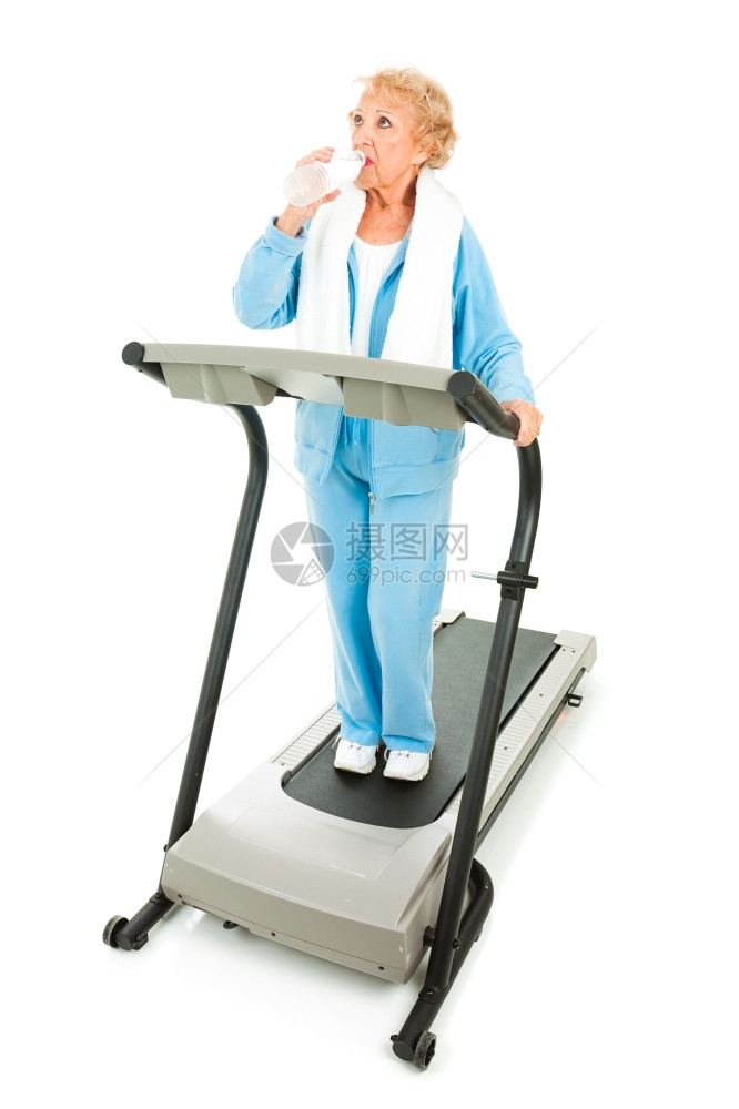健壮的年长女子在跑步机上工作休息一段时间保持水分不足图片