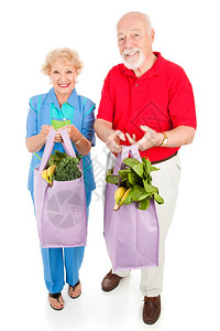 老年夫妇把新鲜产品带回家装在可再用布料杂货袋中全身被白色隔绝图片