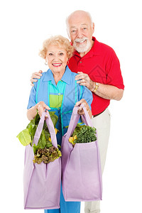 老年夫妇用可重新使的购物袋把食带回家背景图片