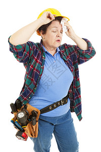 疲劳的女建筑工人擦前额的汗水图片
