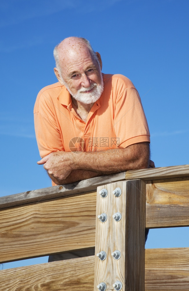 一个英俊体贴的老人肖像仰赖着木栏杆图片