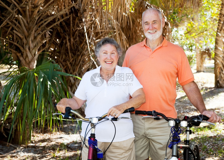快乐的老年夫妇享受骑自行车在一起图片