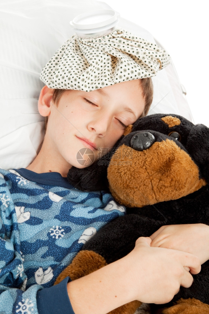 在家生病的小男孩躺在床上睡觉与他的填充动物图片