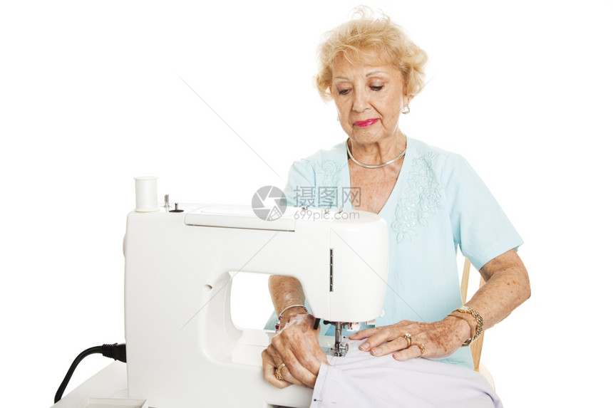 高级女人在缝纫机上做窗帘白的孤立无援图片