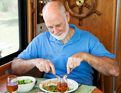 老人享受着健康的晚餐火鸡青豆和沙拉在他的汽车家图片