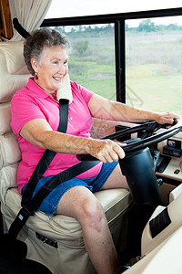 年长妇女享受驾车回家的豪华汽图片