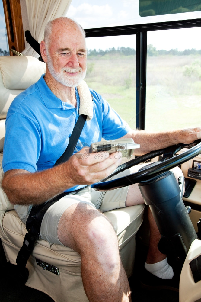 高级男子使用GPS导航驾驶他的发动机回家图片