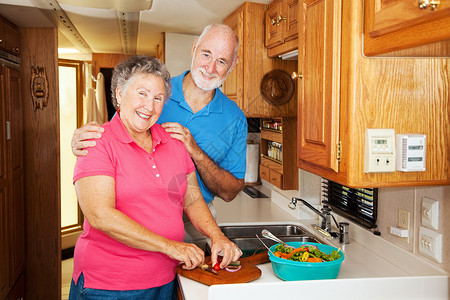 老年夫妇一起在他们的运动之家厨房做饭图片