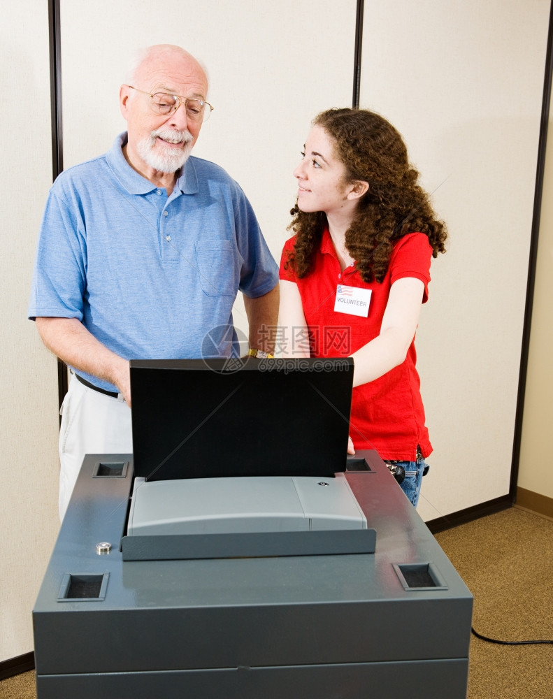 志愿者在选举日向一位资深人士解释新的光学扫描投票机图片