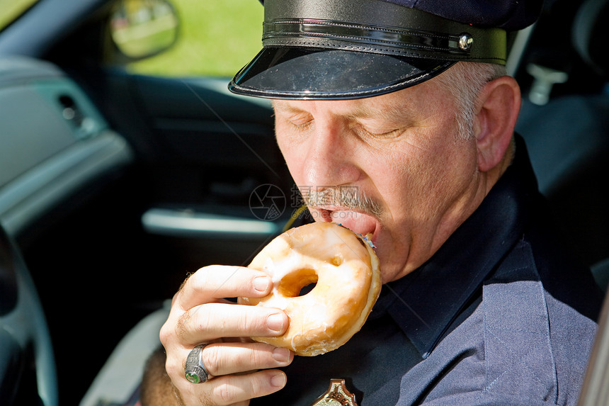 警官咬一个美味的甜圈图片