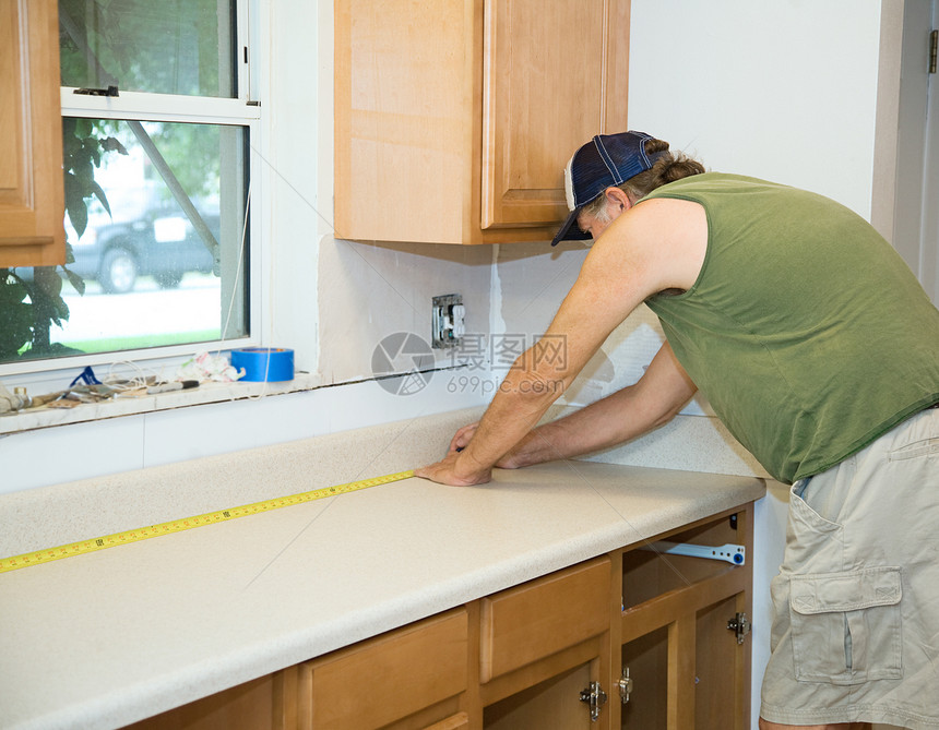 在厨房改造期间木匠测量层板的顶部图片