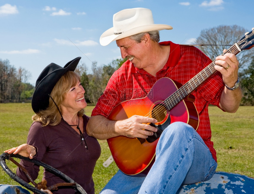 英俊成熟的歌唱牛仔调情与他美丽的妻子图片