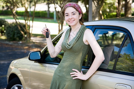 年轻女孩靠着她的新车拿钥匙图片