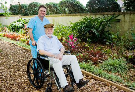 护理员带一个老人去花园散步背景图片
