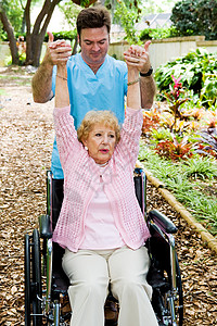 理疗师帮助残疾的老年妇女恢复上肢运动能力图片