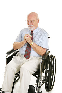 坐在轮椅上的老人祈祷要恢复健康孤立在白色上图片