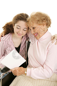 外婆坐在轮椅上阅读外孙女的妈日或取得健康卡片图片