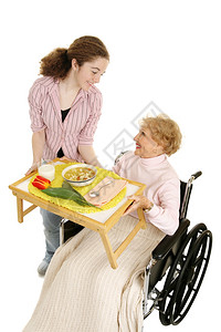 老年残疾人由友善的青少年志愿者提供家庭用餐白色的垂直视图被隔开图片