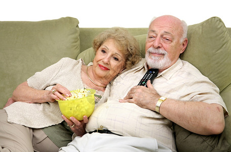 一对年长夫妇起在沙发上放松一起看电视图片