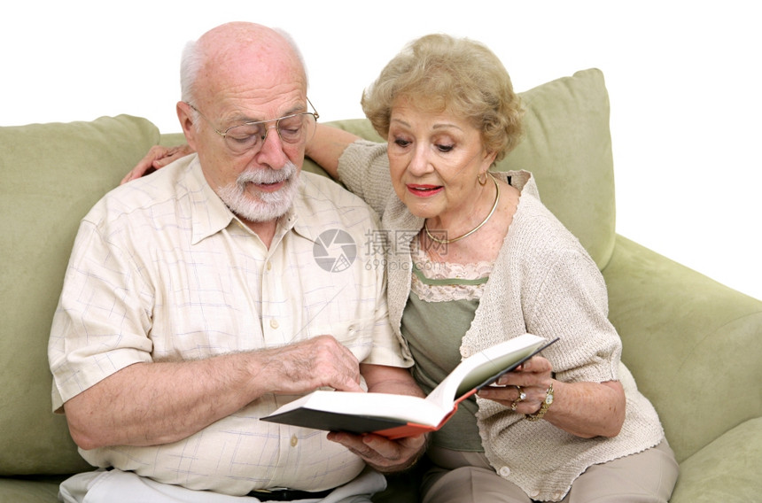 年老的夫妇坐在沙发上一起读书图片