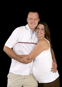 快乐笑的怀孕夫妇黑色背景图片