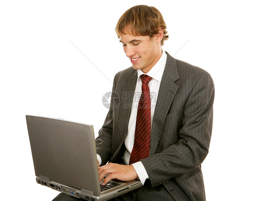 英俊的年轻商人在笔记本电脑上打字孤立在白色上图片