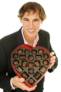 英俊的年轻人向你提供情节巧克力孤立的白色图片