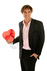 英俊的年轻人拿着一盒心形的情人节糖果白色的孤立无援图片