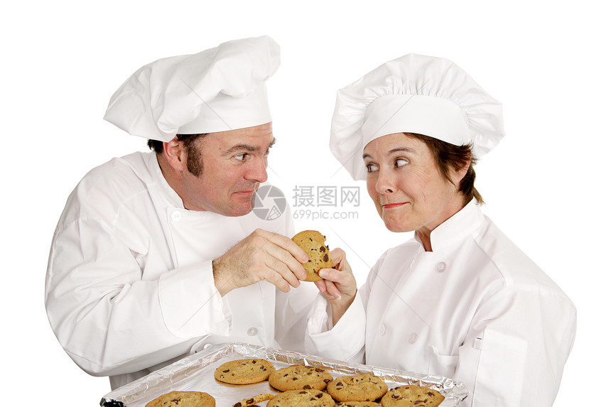 两个厨师为了一新鲜的巧克力饼干打架白着孤立的图片