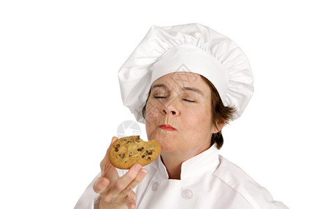 厨师享受她刚烤的美味巧克力曲奇饼孤立的白色图片
