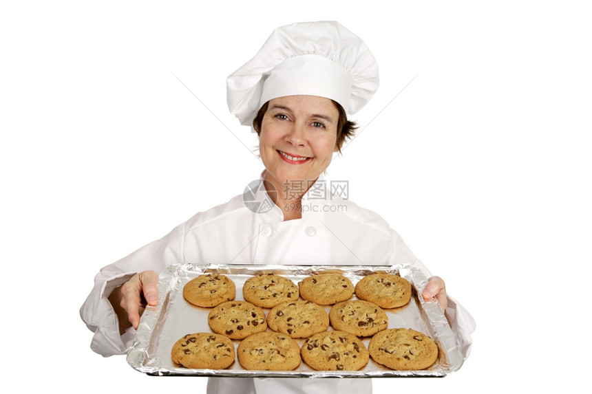 漂亮的女厨师拿着一盘新鲜的烤巧克力饼干白色的孤立无援图片