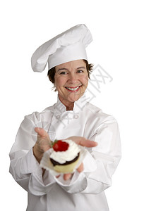 一位可爱的糕点厨师拿着她刚做的甜点图片