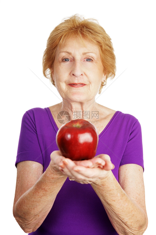 健康的老太拿着闪亮的红苹果孤立在白色上图片