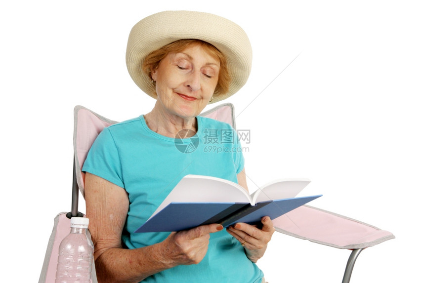 一位漂亮的女士躺在沙滩椅上看书孤立的白种人图片