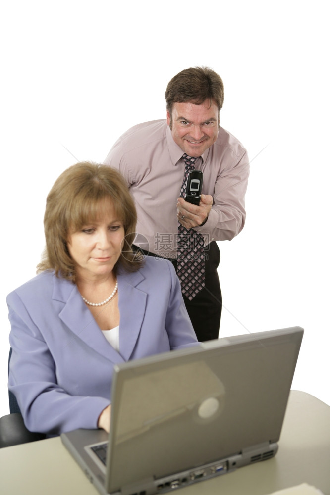 一个拥有照相机电话的男人背着她拍摄同事电脑屏幕的照片白人孤立无援专注男图片