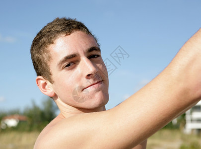一位英俊的晒黑年轻人在夏天外出露营的特写肖像图片