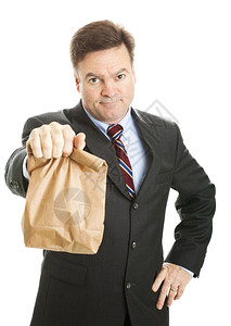 商人通过带午餐在棕色袋子里工作来节省钱他看起来并不高兴孤立无援图片