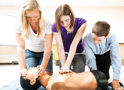 学生们在模特上练习CPR救生技术图片