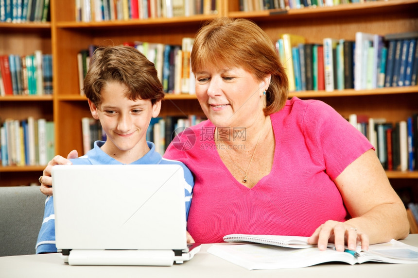 母亲或教师用图书馆的电脑上学习图片