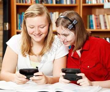 两个少女在学校图书馆发短信背景图片