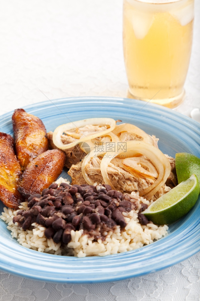 古巴传统的黑豆和大米烤猪肉炸薯条晚餐图片
