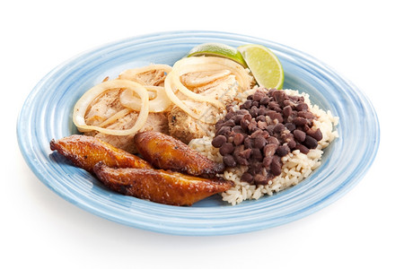 美味的古巴晚餐配有烤猪肉黑豆大米和炸薯条图片