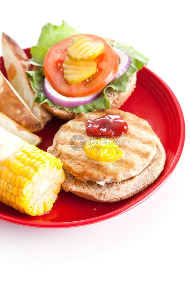 一个健康的火鸡汉堡垂直孤立视图放在整个谷物包上烤土豆和玉米在鳕鱼上图片
