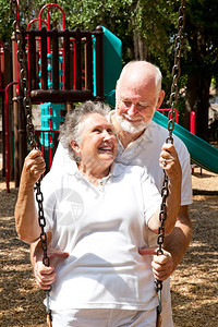 老年夫妇在游乐场摇摆秋千板上图片