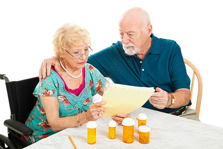 残疾老年妇女及其丈夫翻阅他们的医药和处方账单图片