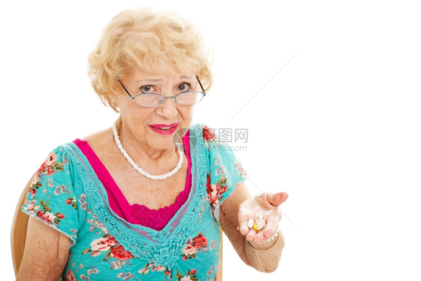 高龄女人拿着一小撮药片却对服用这些药不高兴图片