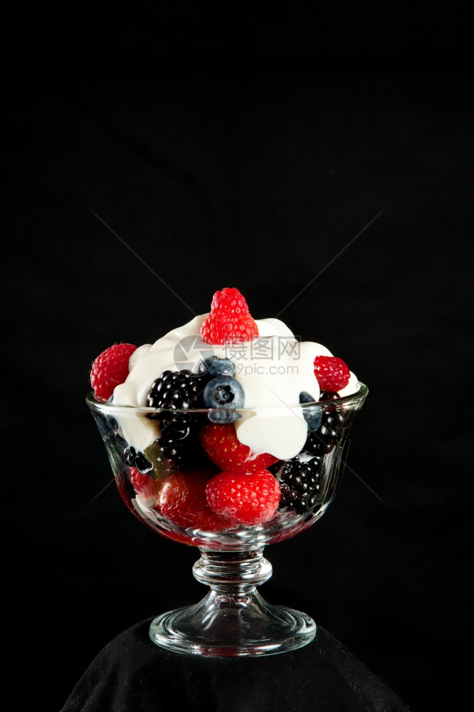 混合浆果的健康甜点加香草希腊酸奶黑色背景和文字空间图片
