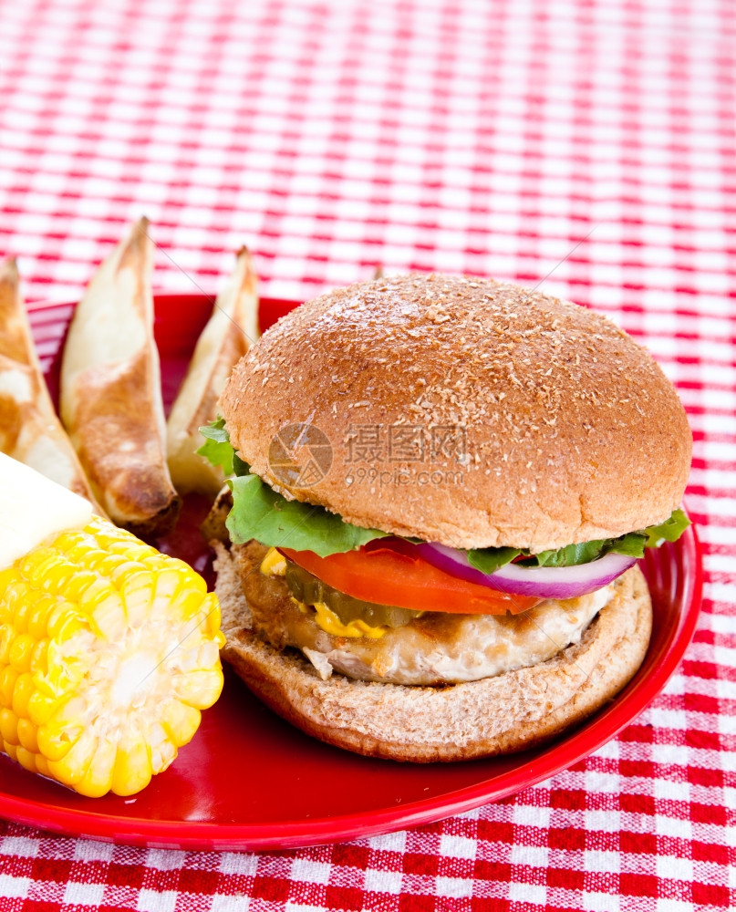 美味健康的火鸡汉堡放在一整包谷物面上烤土豆和玉米在鳕鱼上图片
