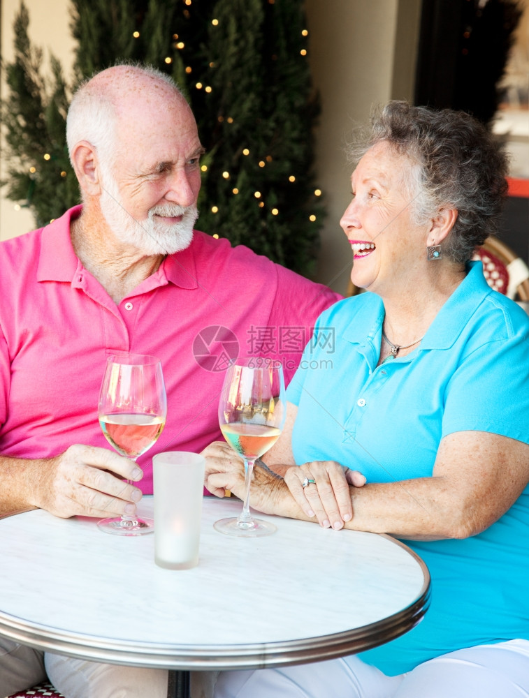 年长夫妇在户外咖啡厅喝着一杯葡萄酒聊天图片